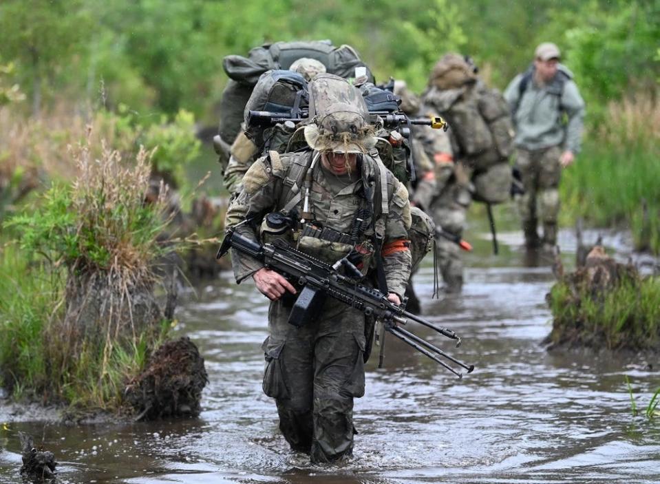 Special Forces candidates assigned to the U.S. Army John F. Kennedy Special Warfare Center and School move through a water obstacle , May 27, 2023, during the final phase of field training known as Robin Sage near Hoffman, North Carolina.