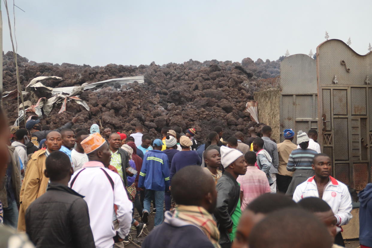 Residents check the damages caused by lava from the overnight eruption of Mount Nyiragongo in Buhene, on the outskirts of Goma, Congo in the early hours of Sunday, May 23, 2021. Congo's Mount Nyiragongo erupted for the first time in nearly two decades Saturday, turning the night sky a fiery red and sending lava onto a major highway as panicked residents tried to flee Goma, a city of nearly 2 million. (AP Photo/Justin Kabumba)