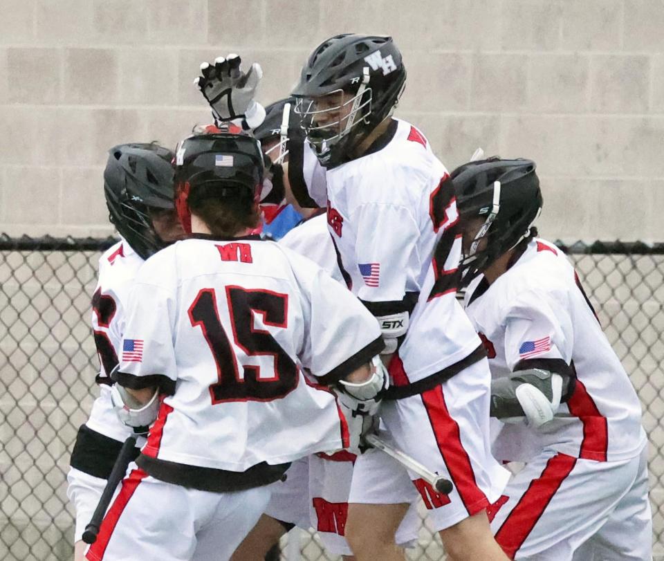 Whitman-Hanson's Luke Tropeano, center, celebrates after scoring a goal to tie the game at 6-6 against Hull on Thursday, March 31, 2022.