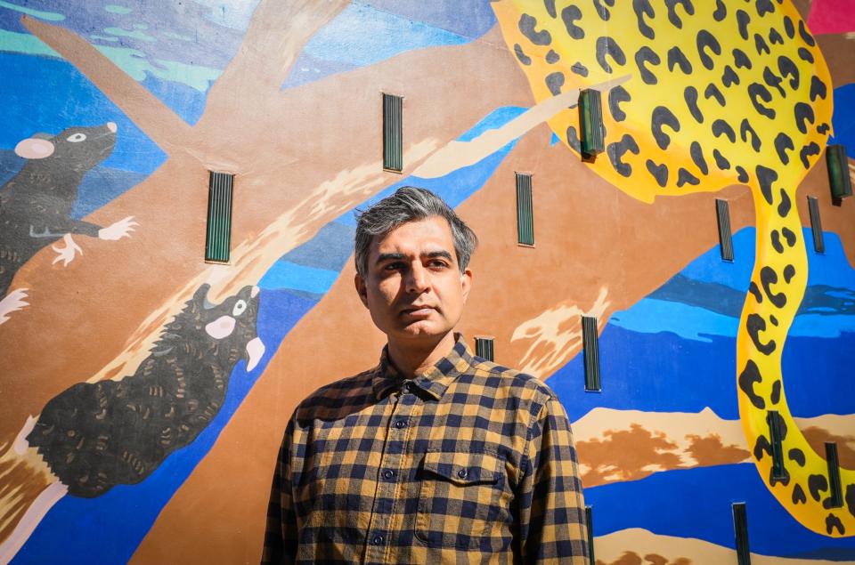 Artist Manik Raj Nakra pictured in front of his mural on the side of The Contemporary Austin at the Jones Center.