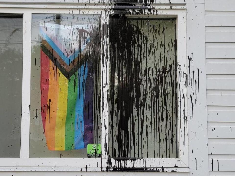 Black paint covers a glass display showcasing a Progress Pride flag at Ladner United Church in Delta, B.C.  (Ladner United Church - image credit)