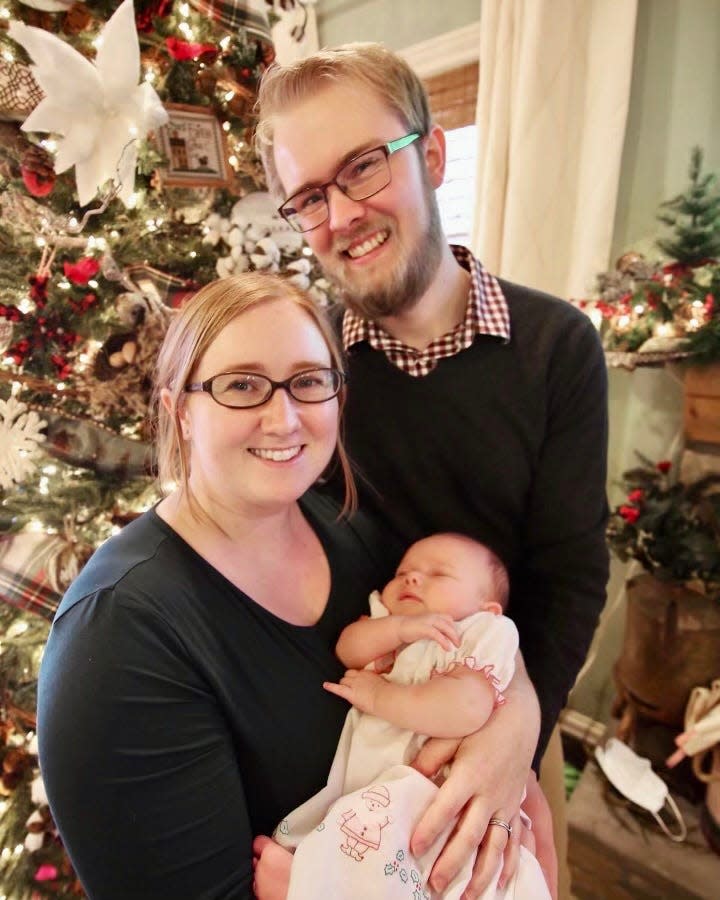 A Christmas 2022 picture of Mallory Corzine Achterbosch  with her husband, Azriel, and their baby, Eliza