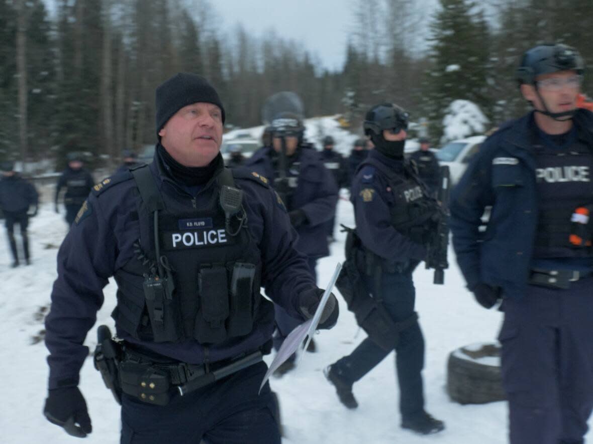 RCMP officers on the Morice River Forest Service Road in northern B.C., on Friday, part of a two-day operation to clear barricades blocking construction of a natural gas pipeline. (Submitted by Dan Loan - image credit)