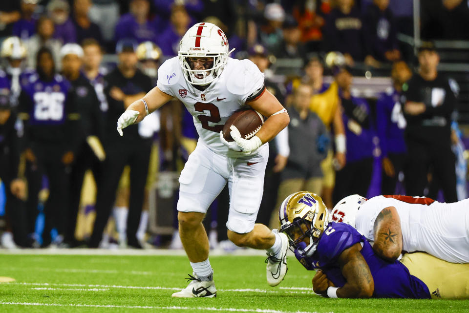 Sep 24, 2022; Seattle, Washington, USA; Stanford Cardinal running back Casey Filkins (left) breaks a tackle attempt by Washington Huskies linebacker Cam Bright (right) during the first quarter at Alaska Airlines Field at Husky Stadium. Mandatory Credit: Joe Nicholson-USA TODAY Sports