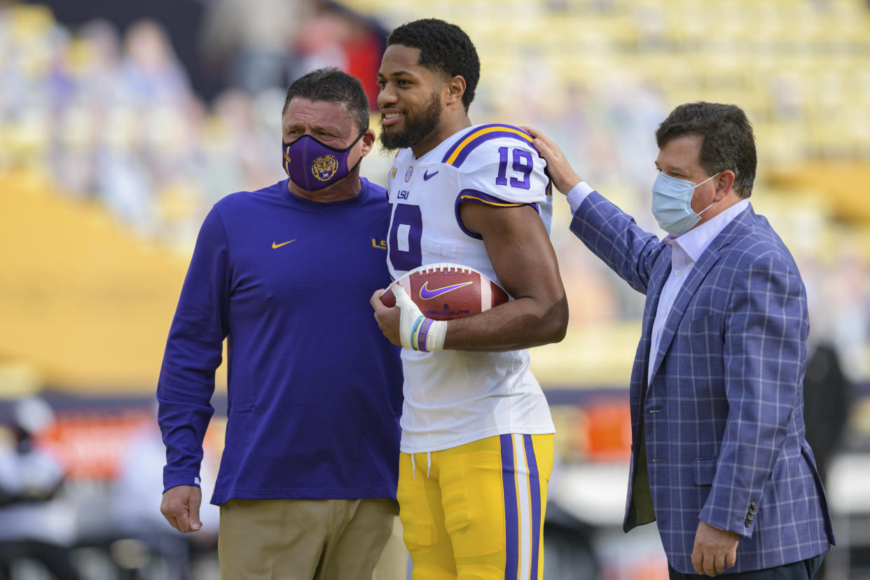 LSU head coach Ed Orgeron takes a senior portrait with LSU linebacker Jabril Cox (19) and LSU Athletic Director Scott Woodward before an NCAA college football game against Mississippi in Baton Rouge, La., Saturday, Dec. 19, 2020. (AP Photo/Matthew Hinton)