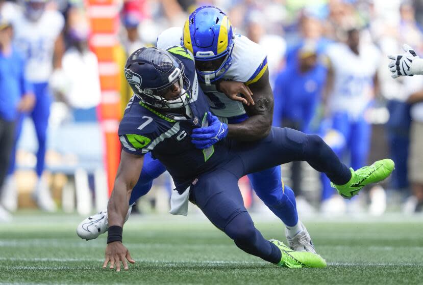 Seattle Seahawks quarterback Geno Smith (7) is sacked by Los Angeles Rams linebacker Byron Young (0) during the second half of an NFL football game, Sunday, Sept. 10, 2023, in Seattle. (AP Photo/Lindsey Wasson)