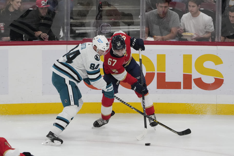 San Jose Sharks defenseman Jan Rutta (84) and Florida Panthers defenseman Mike Reilly (6) go after the puck during the second period of an NHL hockey game, Tuesday, Oct. 24, 2023, in Sunrise, Fla. (AP Photo/Marta Lavandier)