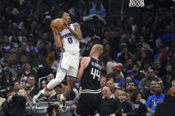 Sacramento Kings guard Malik Monk, left, shoots as Los Angeles Clippers center Mason Plumlee defends during the first half of an NBA basketball game Friday, Feb. 24, 2023, in Los Angeles. (AP Photo/Mark J. Terrill)