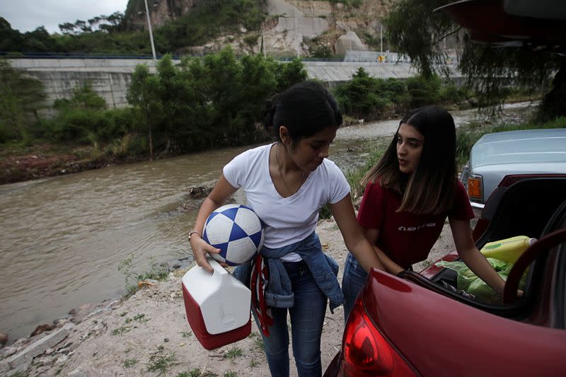 Residents arrange their belongings in the trunk of their car whilst evacuating their house in anticipation of heavy rains as Hurricane Iota approaches, in Tegucigalpa