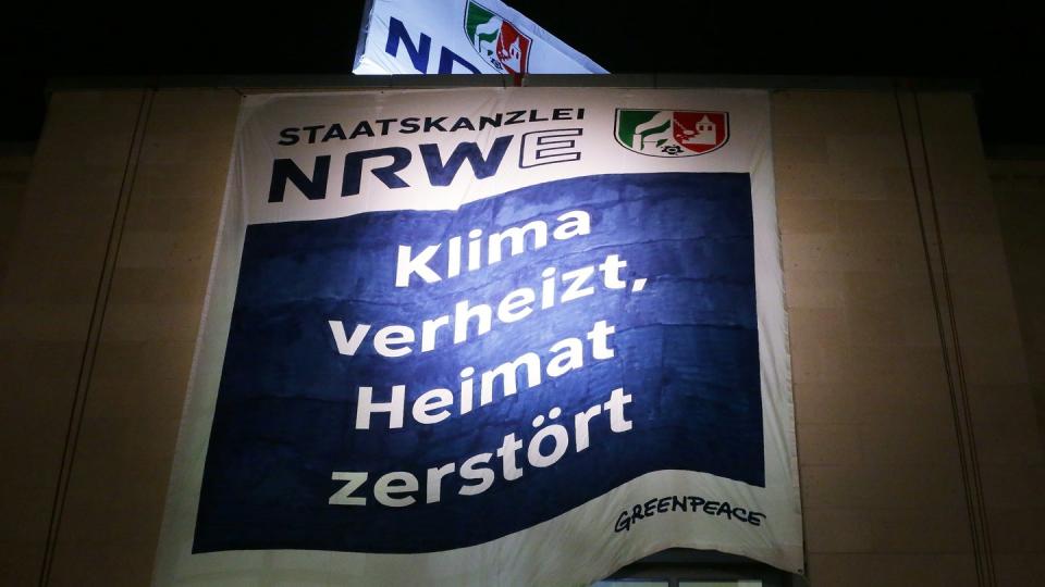 Greenpeace Aktivisten haben am Düsseldorfer Staatskanzlei zwei Banner aufgespannt. Auf dem Banner steht «Staatskanzlei NRWE: Klima verheizt, Heimat zerstört».