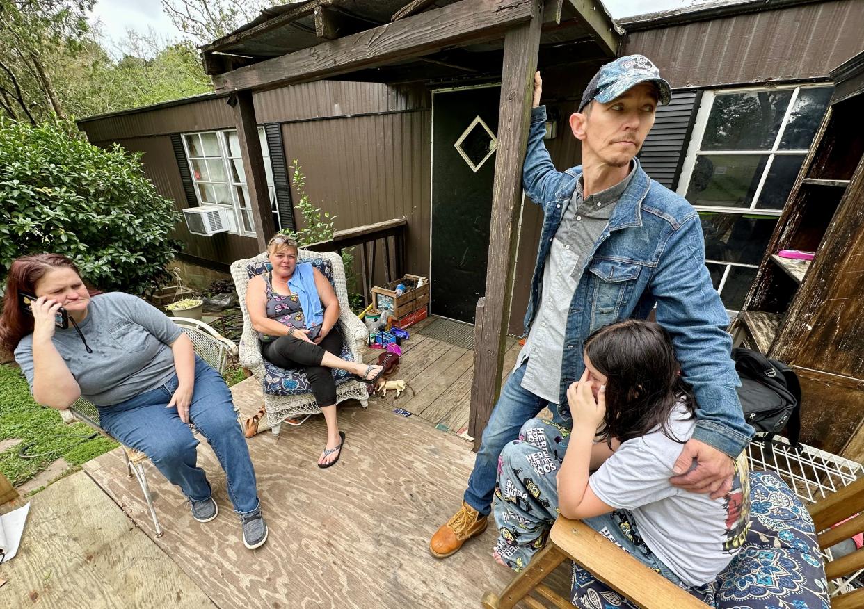 The Cooper family gathers on the front porch of their home on Peachtree Drive on March 26, 2024, the day after Shawn Cooper Jr., 18, was fatally shot in an incident at a home down the street. Pictured, clockwise from left, are Merrie Cooper, his mom, Lori Keigans, his aunt, Shawn Cooper Sr., his dad, and Mariyah Cooper, his younger sister.