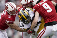 FILE - Wisconsin's linebackers Leo Chenal (5) and Nick Herbig (19), and safety Scott Nelson (9), wrap up Iowa running back Tyler Goodson (15) during the first half of an NCAA college football game Saturday, Oct. 30, 2021, in Madison, Wis. Across the country, college football teams once again are discovering that establishing a rushing attack is even tougher than it was the year before. (AP Photo/Andy Manis, File)