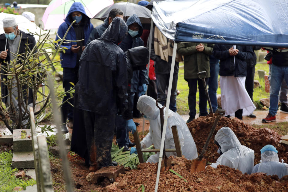 FILE - In this July 10, 2020, file photo, undertakers wearing personal protective equipment exit the grave of COVID-19 victim Shaykh Seraj Hassan Hendricks during his burial at the Mowbray cemetery in Cape Town, South Africa. For months, the city of Cape Town was the biggest coronavirus hot spot in Africa. Now, finally, there are signs of relief. (AP Photo/Nardus Engelbrecht, File)