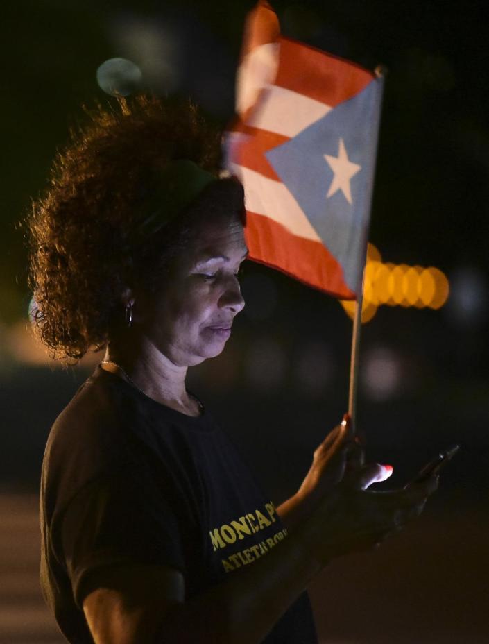 A woman waves a Puerto Rican flag outside the Federal Courthouse building after learning that President Barack Obama commuted the sentence for Puerto Rican nationalist Oscar Lopez Rivera, in San Juan, Puerto Rico, Tuesday, Jan. 17, 2017. Many Puerto Ricans have long demanded his release, and some wept with emotion upon hearing the news while others began preparing for all-night parties announced on social media. (AP Photo/Carlos Giusti)