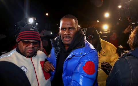 R. Kelly turns himself in at 1st District police headquarters in Chicago on Friday night - Credit: AP