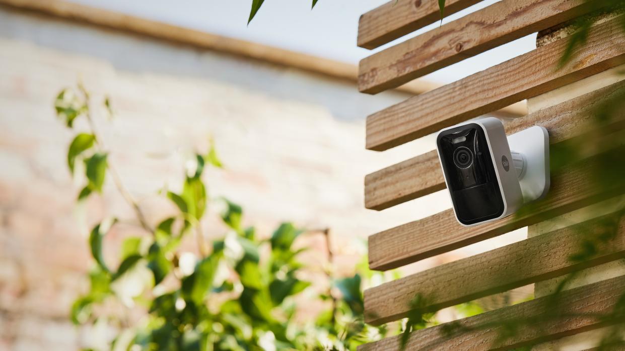  Yale Smart Outdoor Camera review: camera mounted up on a wooden wall. 