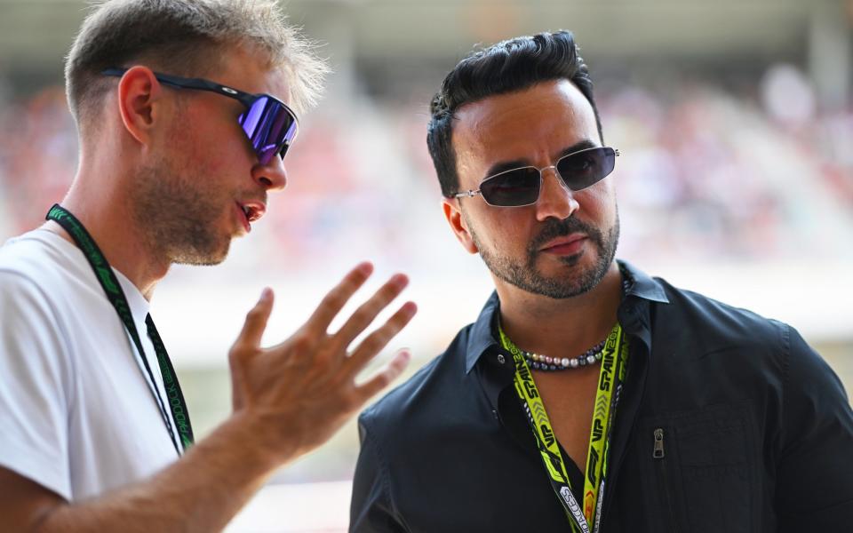 Singer Luis Fonsi being given a tour in the Red Bull garage