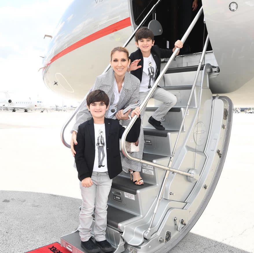 Celine Dion and two children in front of a plane