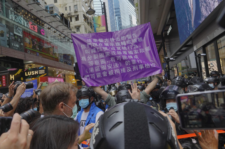 2020年7月1日國安法執行首日，同時也是香港主權移交23周年，部分香港民眾依舊上街表達訴求，港警首度出示了新版紫色警告旗。圖片來源：AP