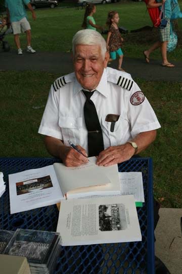 Richard Haynes signs a copy of his history of the Rohrersville Band, "And the Band Played On," in 2016 at Boonsboro's Shafer Park