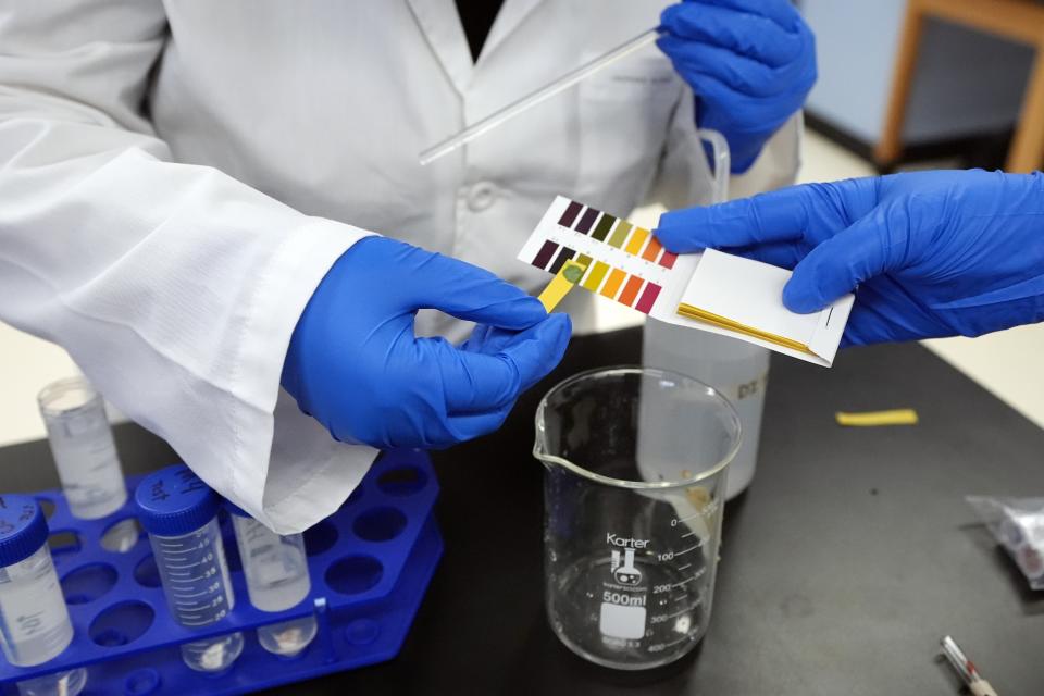 Sima Gutierrez checks the pH levels of a water sample at the Flint Community Water Lab, Wednesday, April 3, 2024, in Flint, Mich. The lab, with more than 60 high school and college interns, has provided free water testing for thousands of residents since 2020. (AP Photo/Carlos Osorio)