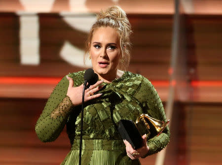 Adele and co-song writer Greg Kurstin (not pictured) accept the Grammy for Song of the Year for "Hello". REUTERS/Lucy Nicholson
