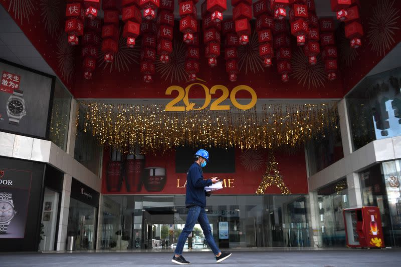 Worker wearing a face mask walks past a shopping mall, following an outbreak of the novel coronavirus in the country, in Kunming, Yunnan