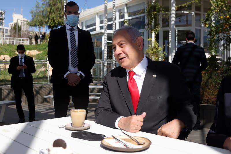 Israel PM Benjamin Netanyahu gestures as he sits in a cafe in Jerusalem