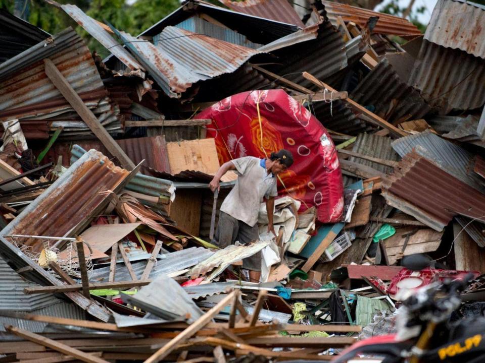 A man looks for his belongings amid the debris of his destroyed house in Palu (AFP/Getty )