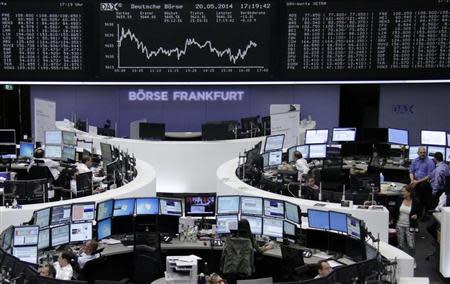 Traders are pictured at their desks in front of the DAX board at the Frankfurt stock exchange May 20, 2014. REUTERS/Remote/Stringer
