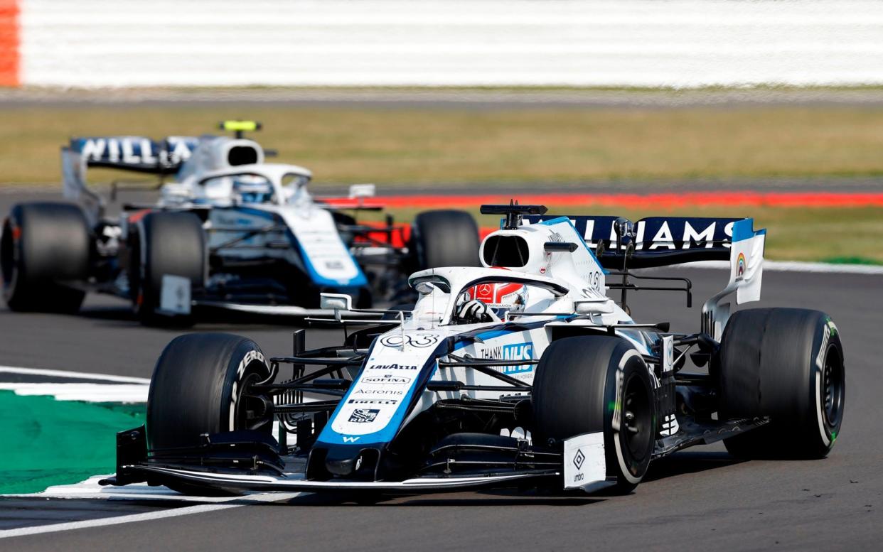 Williams' British driver George Russell (right) leads his teammate, Canadian driver Nicholas Latifi (left), through a corner during the 70th Anniversary Grand Prix at Silverstone - AFP