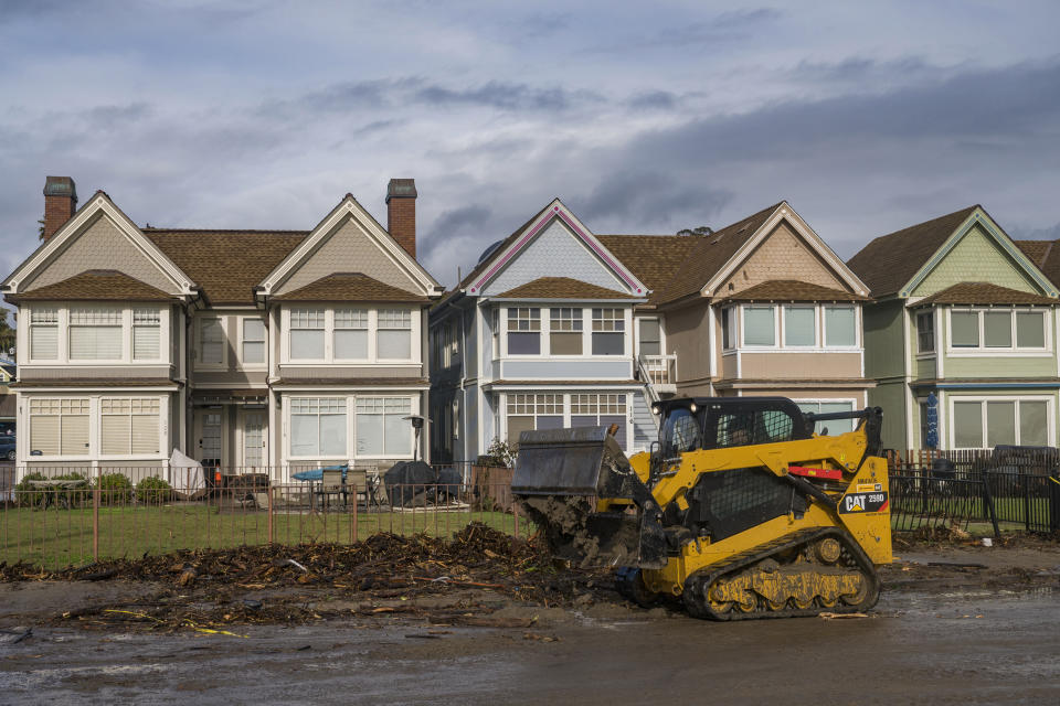 A bulldozer clears debris in Capitola, Calif., Thursday, Jan. 5, 2023. Damaging hurricane-force winds, surging surf and heavy rains from a powerful “atmospheric river” pounded California on Thursday, knocking out power to tens of thousands, causing flooding, and contributing to the deaths of at least two people, including a child whose home was hit by a falling tree. (AP Photo/Nic Coury)