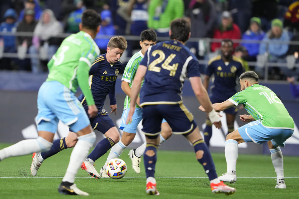 Vancouver Whitecaps midfielder Ryan Gauld, second from left, looks to shoot against Seattle Sounders midfielder Alex Roldan (16) during the second half of an MLS soccer match Saturday, April 20, 2024, in Seattle. (AP Photo/Lindsey Wasson)