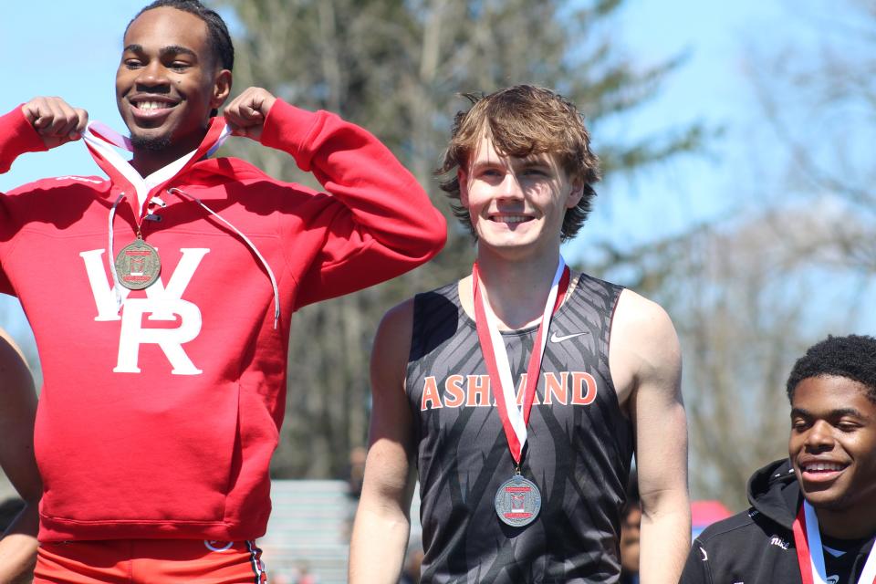 Ashland's Jacob Holbrook smiles on the podium after finishing second in the 100 meters to Walnut Ridge's Zayvion Mallory (left).