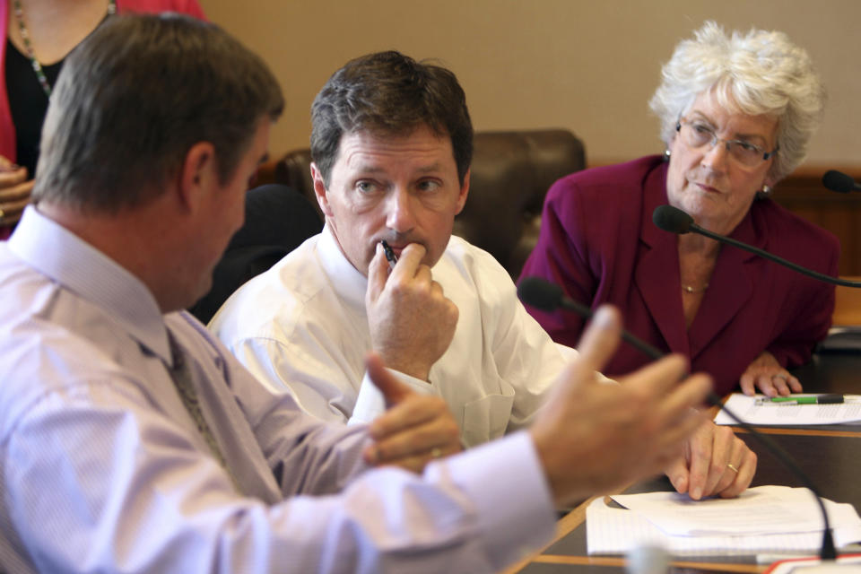 FILE - State Rep. Tom Sherman, D-Rye, center, and state Sen. Nancy Stiles, R-Hampton, listen to state Sen. Andy Sanborn on Oct. 2, 2013, in Concord, N.H. during a break in the meeting of the special commission charged with recommending whether New Hampshire should expand Medicaid. Sherman is running unopposed for his party's nomination for governor. (AP Photo/Jim Cole)