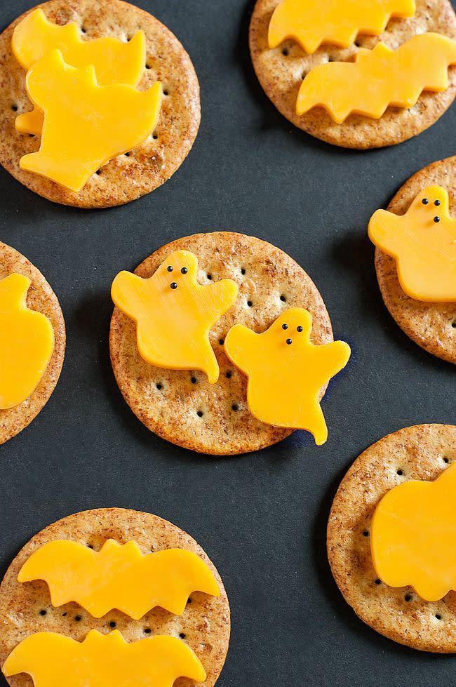 <p>Mini cookie cutters — ghosts, bats, cats and more — give your cheese slices the perfect amount of Halloween magic. </p><p>Get the <strong><a href="https://peasandcrayons.com/2015/10/spooky-snacks-and-healthy-halloween-treats.html" rel="nofollow noopener" target="_blank" data-ylk="slk:Spooky Cheese and Crackers recipe;elm:context_link;itc:0;sec:content-canvas" class="link ">Spooky Cheese and Crackers recipe</a></strong> from Peas and Crayons. </p>