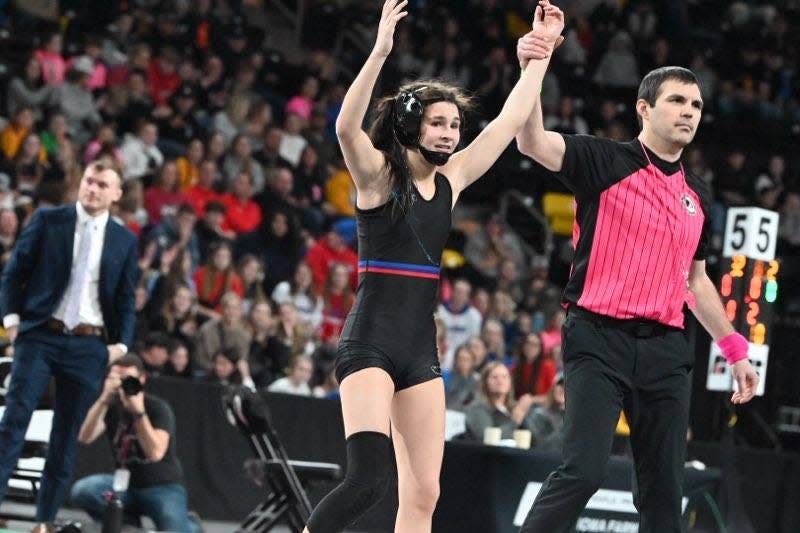 Raccoon River-Northwest's Katie Biscoglia has her hand raised after winning the 2024 state title at 100 pounds.