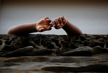 A child is seen on a balcony after being forcibly removed from a building where they had been living, in central Rome, Italy, August 20, 2017. REUTERS/Alessandro Bianchi