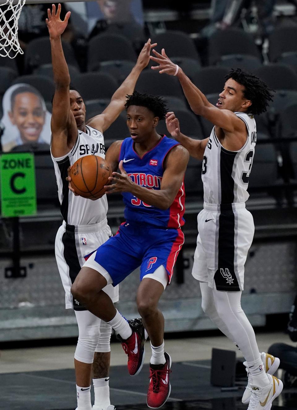 Pistons guard Saben Lee, center, drives between Spurs guard Devin Vassell, left, and guard Tre Jones, right, during the first half in San Antonio, Thursday, April 22, 2021.