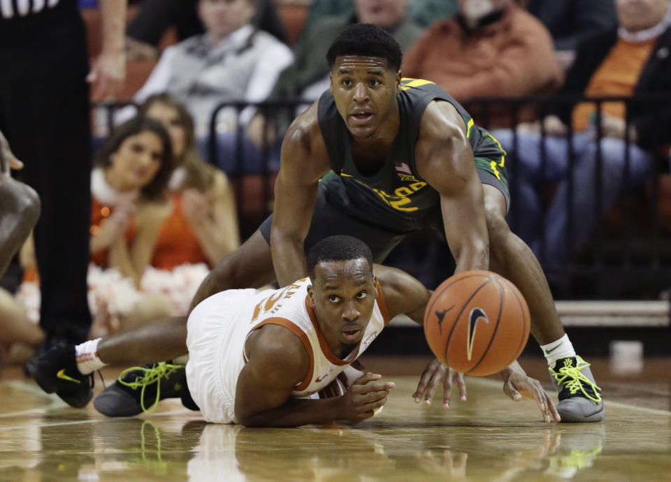 Texas guard Matt Coleman III, bottom, and Baylor guard Jared Butler, right, chase the ball during the first half of an NCAA college basketball game, Monday, Feb. 10, 2020, in Austin, Texas. (AP Photo/Eric Gay)