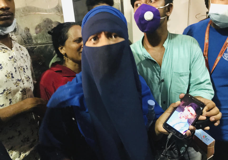 A woman shows a photograph of her young boy who has gone missing after a gas pipeline explosion, at a hospital in Dhaka, Bangladesh, Saturday, Sept. 5, 2020. An underground gas pipeline near a mosque exploded during evening prayers outside the capital of Bangladesh, leaving at least 11 Muslim worshipers dead and dozens injured with critical burns, officials said Saturday. The blast occurred Friday night as people were finishing their prayers at Baitus Salat Jame Mosque at Narayanganj, local police chief Zayedul Alam said. (AP Photo/Al-emrun Garjon)