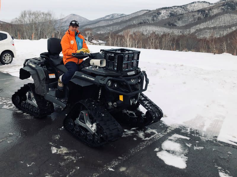 Masami Yashima, manager of Okushiga Kogen snow resort, sits on a snow quad in a car park in the winter season in Nagano