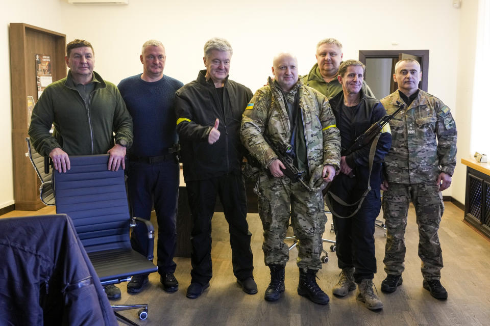 Civilian defense headquarters leaders, from left, former head of Kyiv criminal police Herman Prystupa, former head of Ukraine's criminal police Serhiy Knyazev, ex-President Petro Poroshenko, ex-secretary of Ukraine's Defence and Security Council Oleksandr Turchynov, first deputy Head of the City Hall Andriy Kryshchenko who heads the civilian defense, City Hall lawmaker Zoryan Shkiryak, pose after a meeting in the City Hall in Kyiv, Ukraine, Sunday, Feb. 27, 2022. A Ukrainian official says street fighting has broken out in Ukraine's second-largest city of Kharkiv. Russian troops also put increasing pressure on strategic ports in the country's south following a wave of attacks on airfields and fuel facilities elsewhere that appeared to mark a new phase of Russia's invasion. (AP Photo/Efrem Lukatsky)