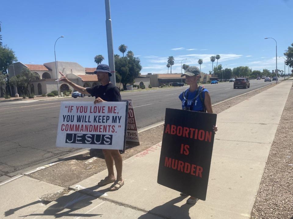 Self-described Christian evangelist Stephanie Mackenzie (right) and GCU student Dominic Lodi (left) were among a handful of protesters outside of a Planned Parenthood in Tempe on Friday. The group said it regularly pickets the site.
