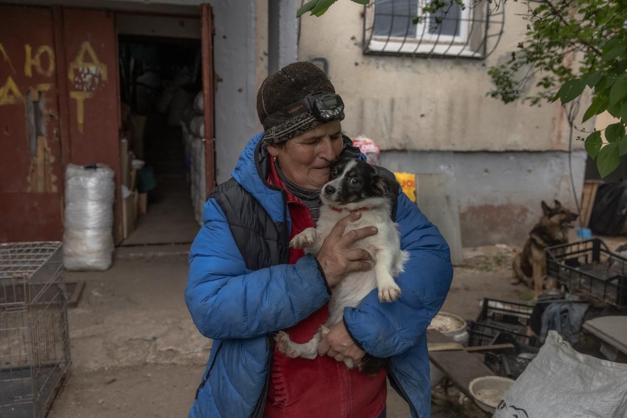 Olena Gubenko, 59-years-old, carries one of her dogs as she evacuates with them from the village of Ruski Tyshky, Kharkiv (AFP via Getty Images)