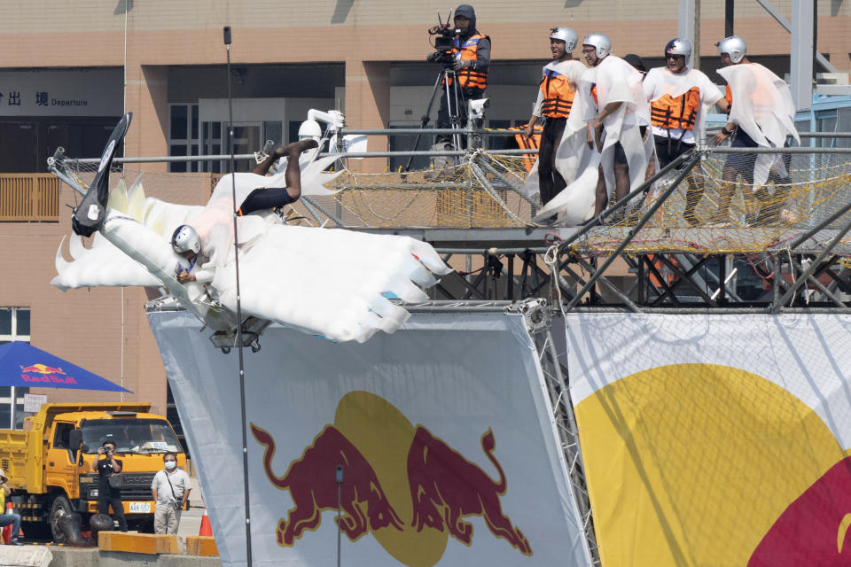 A team member jumps from a platform with a man made flying machine into the harbor in Taichung, a port city in central Taiwan on Sunday, Sept. 18, 2022. Pilots with homemade gliders launched themselves into a harbor from a 20-foot-high ramp to see who could go the farthest before falling into the waters. It was mostly if not all for fun as thousands of spectators laughed and cheered on 45 teams competing in the Red Bull “Flugtag” event held for the first time. (AP Photo/Szuying Lin)