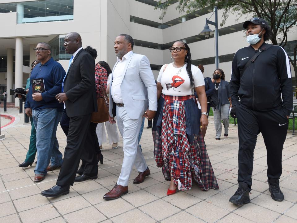 Attorney Ben Crump, second from left, walks with Ron Lacks, left, Alfred Lacks Carter, third from left, both grandsons of Henrietta Lacks, and other descendants of Lacks, outside the federal courthouse in Baltimore, Oct. 4, 2021. The family of Henrietta Lacks is settling a lawsuit against a biotechnology company it accuses of improperly profiting from her cells.