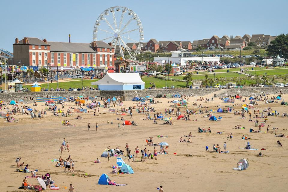 Sunseekers enjoy the sunny weather at Barry Island on Friday (PA)