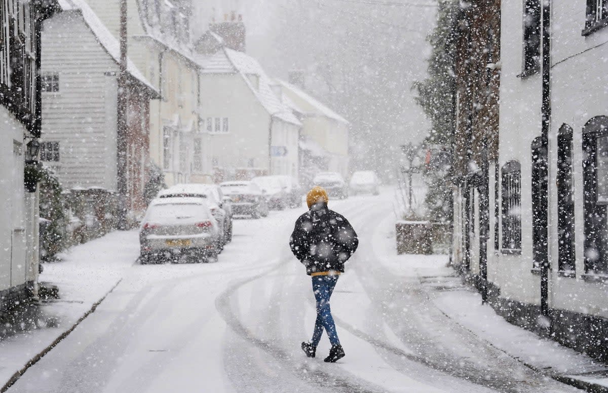 A person walking through a snow flurry in Lenham, Kent.  Sleet and snow showers battered the UK on Monday  (PA)