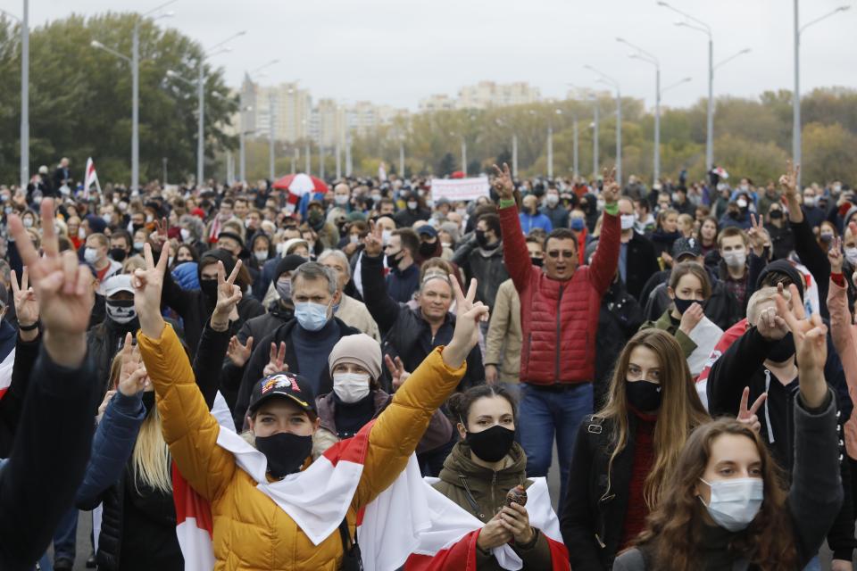 People with old Belarusian national flags march during an opposition rally to protest the official presidential election results in Minsk, Belarus, Sunday, Oct. 25, 2020. The demonstrations were triggered by official results giving President Alexander Lukashenko 80% of the vote in the Aug. 9 election that the opposition insists was rigged. Lukashenko, who has ruled Belarus with an iron fist since 1994, has accused the United States and its allies of fomenting unrest in the ex-Soviet country. (AP Photo)